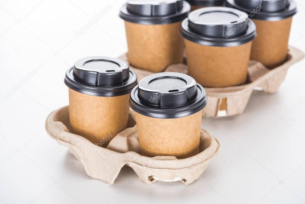 paper cups with coffee in cardboard tray on white background 