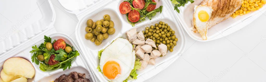 panoramic shot of eco packages with apples, vegetables, meat, fried eggs and salads on white background 