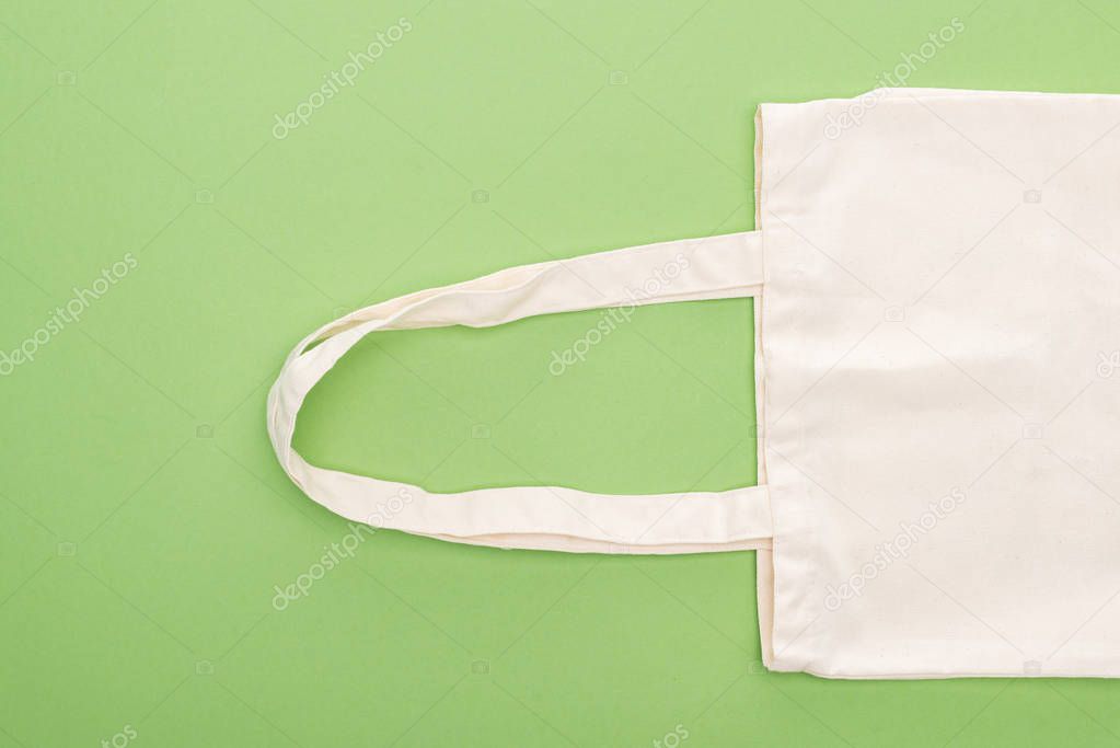 top view of empty cotton eco bag isolated on green