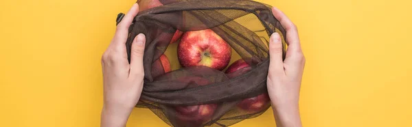 黄色のパノラマショットで隔離されたリンゴとエコフレンドリーなバッグを持つ女性のトリミングビュー — ストック写真
