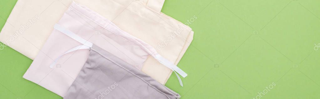 top view of empty cotton eco bags isolated on green, panoramic shot