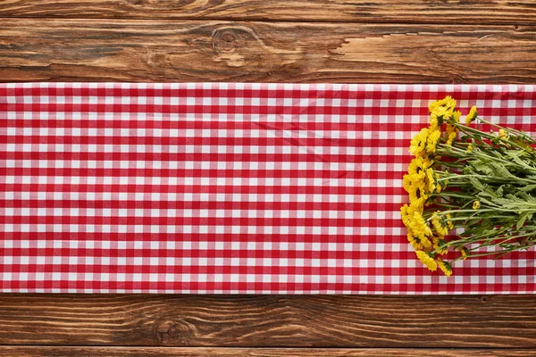 Bovenaanzicht Van Gele Wilde Bloemen Ruitvormige Rode Servet Houten Tafel — Stockfoto