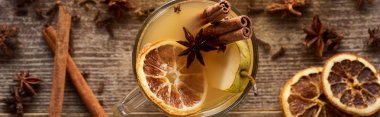 top view of traditional pear mulled wine in glass with spices on wooden rustic table, panoramic shot clipart