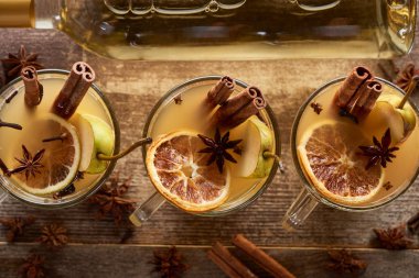 top view of seasonal pear mulled wine cocktails with spices and dried citrus on wooden rustic table clipart