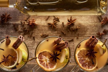 top view of seasonal pear mulled wine cocktails with spices and dried citrus on wooden rustic table clipart