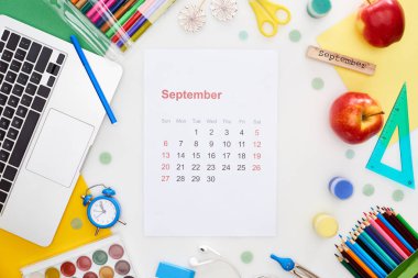 Eylül takvim sayfası, dizüstü bilgisayarı, elmalar, okul malzemeleri, çok renkli kağıtlar, Eylül ayına ait yazılı tahta bloklar beyaz üzerine izole edilmiş. 