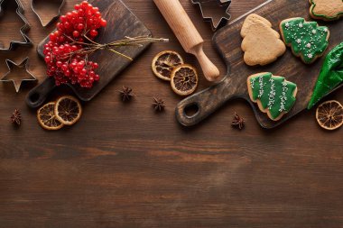 Viburnum yakınındaki Noel kurabiyelerinin ve ahşap masadaki baharatların üst görüntüsü.