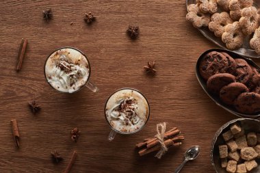 Noel kakaosunun en üst manzarası, ahşap masada krema ve baharat ve kurabiyelerle.