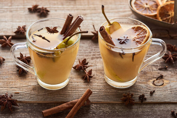 seasonal traditional pear mulled wine with spices in glasses on wooden rustic table