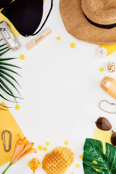 деревянный блок с надписью июня, цифровая камера, цветок лилии, зеленые листья, солнцезащитные очки, солнцезащитный крем, вафли с леденцами, бюстгальтер бикини изолирован на белом
