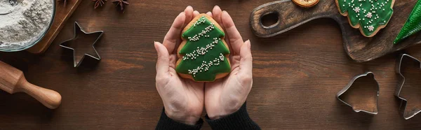 Vista Recortada Mujer Sosteniendo Galleta Del Árbol Navidad Mesa Madera — Foto de Stock