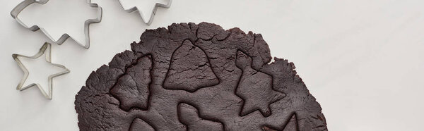 top view of raw dough for chocolate Christmas cookies on white background near dough molds, panoramic shot