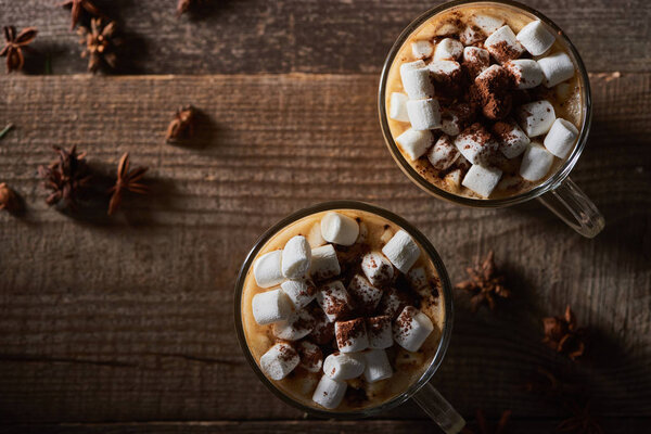 top view of Christmas cacao with marshmallow on wooden table with anise
