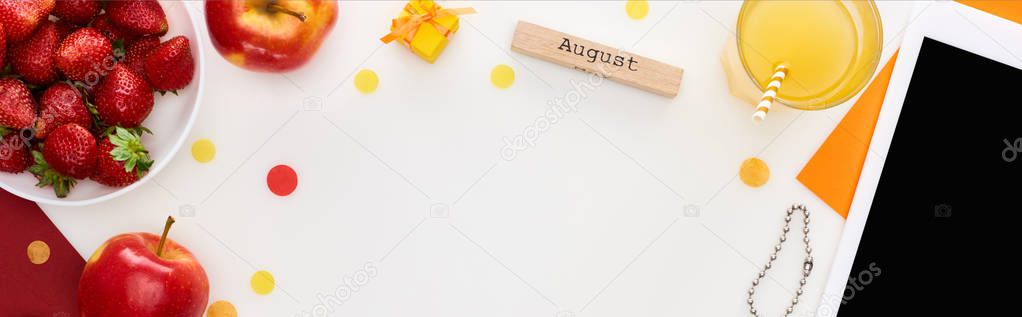 panoramic shot of wooden block with august inscription, fresh strawberry, orange juice, digital tablet, bracelet isolated on white