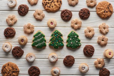 Tahta beyaz masada Noel ağacı kurabiyelerinin üst görüntüsü