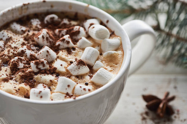 close up view of Christmas cacao with marshmallow and cacao powder in mug