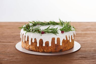 Beyaz kremalı, biberiyeli ve ahşap masadaki yaban mersinli lezzetli Noel pastası. 