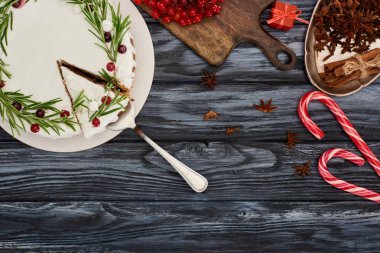 top view of christmas pie with rosemary and cranberries on dark wooden table with candy canes, viburnum berries and star anise seeds clipart