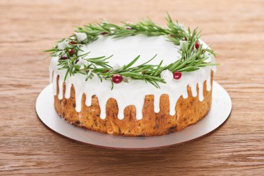 Biberiyeli noel pastası ve ahşap masada kızılcık tabağı. 