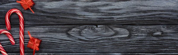 Widok Góry Małe Prezenty Cukierki Laski Ciemnym Drewnianym Stole — Zdjęcie stockowe