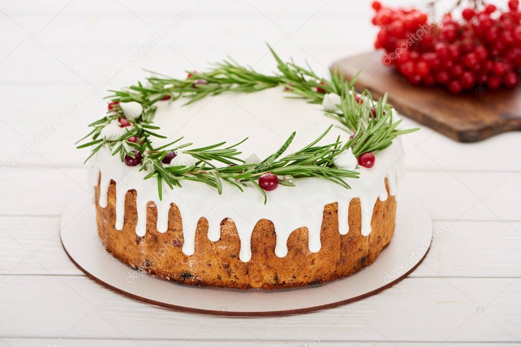 christmas pie with rosemary and viburnum berries on white wooden table  