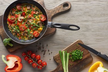Tahtadaki malzemelerle kızartma tavasında leziz omlet manzarası