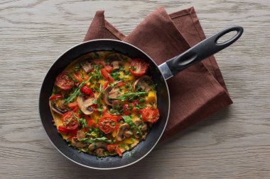 Tahta masada peçeteli sebzeli sebzeli omlet manzarası.