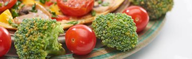 close up of homemade omelet on plate with fresh tomatoes and broccoli