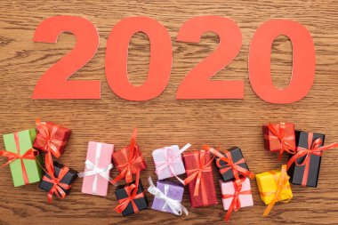Kağıt 2020 rakamlarının üst görünümü küçük dekoratif hediye kutularının yanında ahşap arka planda
