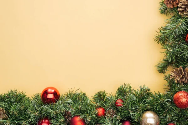 Bovenaanzicht Van Kerstboom Tak Met Rode Gouden Kerstballen Gele Achtergrond — Stockfoto