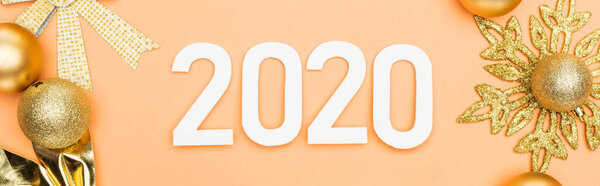 top view of white 2020 numbers near golden christmas decoration on orange background, panoramic shot