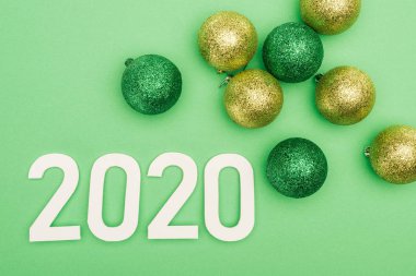 Yeşil arkaplanda noel yakındaki beyaz 2020 sayısının en üst görünümü