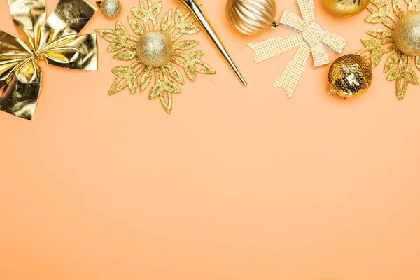 橙色背景下带有复制空间的节日金色圣诞装饰品的顶部视图 — 图库照片
