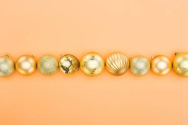 Top View Golden Christmas Baubles Row Orange Background — Stock Photo, Image