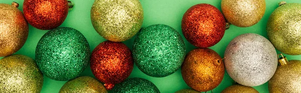 Vrchní Pohled Pestrobarevné Lesklé Vánoční Ozdoby Zeleném Pozadí Panoramatický Záběr — Stock fotografie