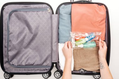 cropped view of woman packing travel bag on white background  clipart