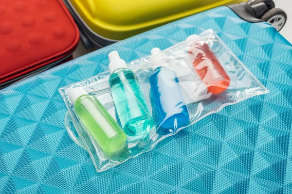 Helle Flaschen Mit Flüssigkeiten Und Kosmetiktasche Auf Reisetasche — Stockfoto