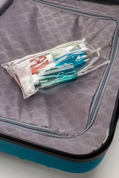 Transparente Kosmetiktasche Mit Bunten Flaschen Auf Reisetasche — Stockfoto