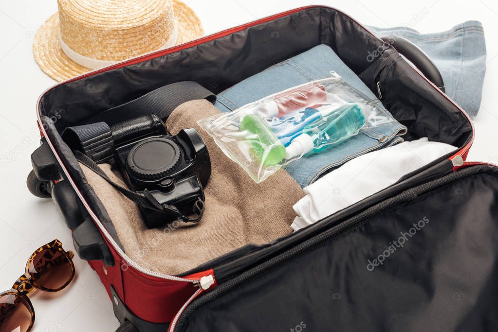 travel bag with towel, cosmetic bag with colorful bottles, digital camera, clothes 