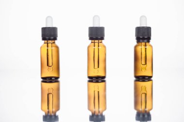 Yüzeyde doğal serum şişeleri ve beyaza yansıyan yansımalar.