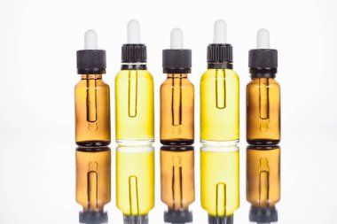 Yüzeyde doğal serum şişeleri ve beyaza yansıyan yansımalar.