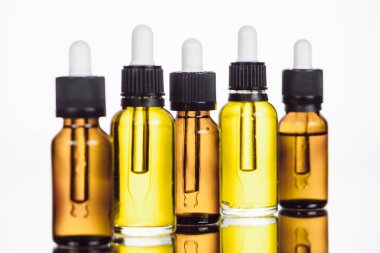 Yüzeyde doğal serum şişeleri ve beyaza yansıyan yansımalar.