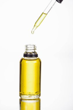 dropper near bottler with natural serum isolated on white clipart