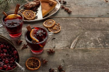 Böğürtlen, anason, portakal dilimleri ve ahşap kırsal masada fotokopi alanı olan tarçın yanında kırmızı baharatlı şarap.