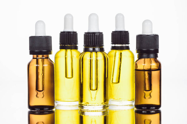 бутылки с натуральной сывороткой на поверхности с отражением изолированы на белом
