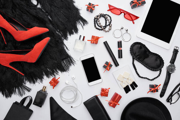 top view of dress, heels, gadgets, gift boxes, sleeping mask, sunglasses, perfume, wristwatch, decorative cosmetics, earrings, earphones, bracelets, bag 