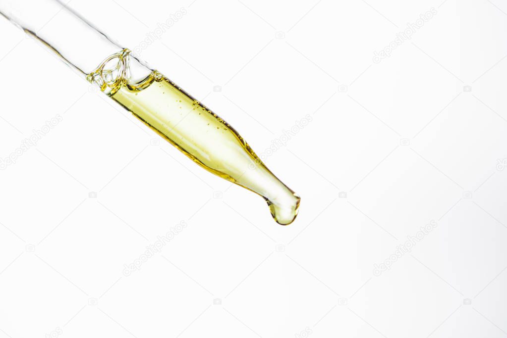 dropper and drop of natural serum isolated on white