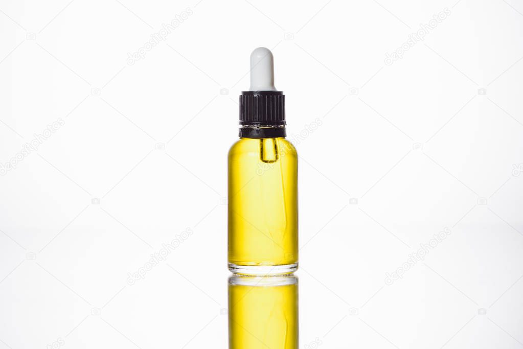 bottle with natural serum on surface with reflection isolated on white