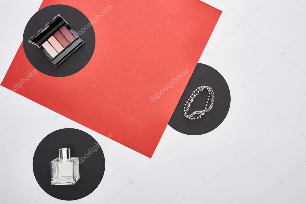 top view of bracelets, eye shadow and perfume 
