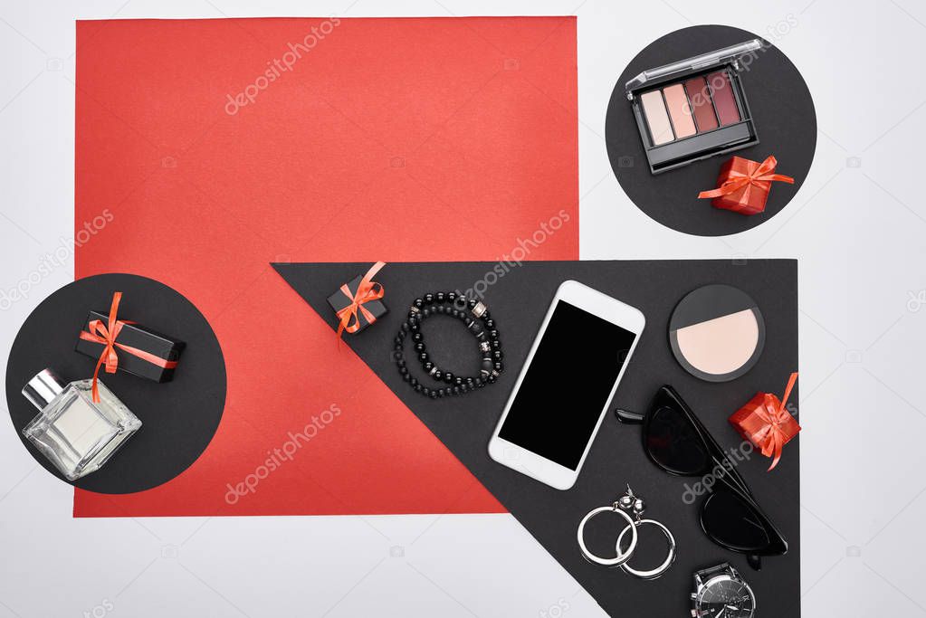 top view of gadget, gift boxes, perfume, earrings, sunglasses